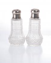 A pair of salt holders with silver tops